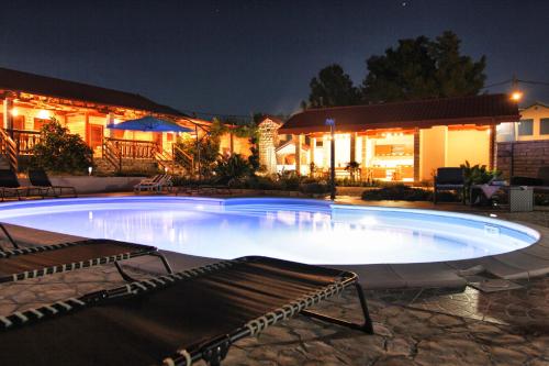 een groot zwembad voor een huis 's nachts bij XxL Ana Biograd na Moru 1-22 gosta in Polača
