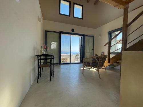 a living room with a table and chairs and a view of the ocean at The Stone House in Votsi
