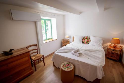 a bedroom with a large white bed and a window at Le Pech Merle YourHostHelper in Saint-Jean-de-Minervois