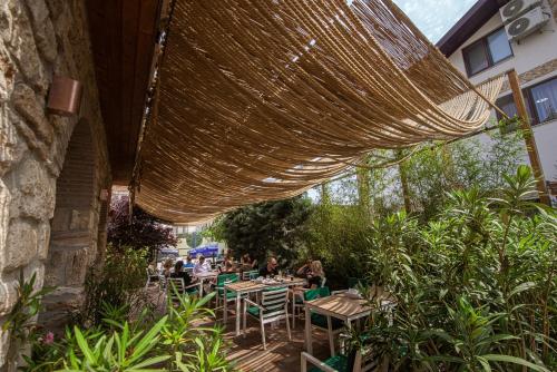 un restaurante con mesas y sillas bajo una sombrilla grande en Artelier Vama Veche, en Vama Veche