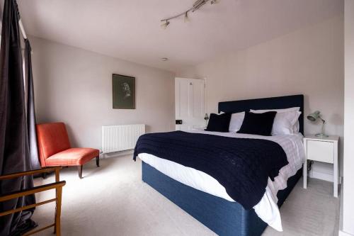 溫徹斯特的住宿－Beautiful & Spacious Retreat in Winchester，一间卧室配有一张大床和一张红色椅子