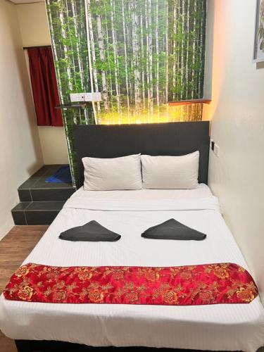 a bedroom with a bed with flowers on it at Hotel Citra in Brinchang