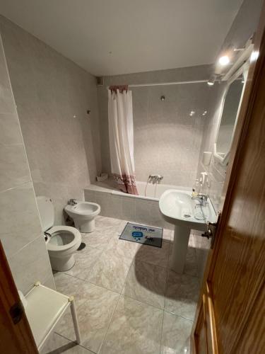 y baño con aseo, lavabo y bañera. en Ajo Playa Homes, en Bareyo