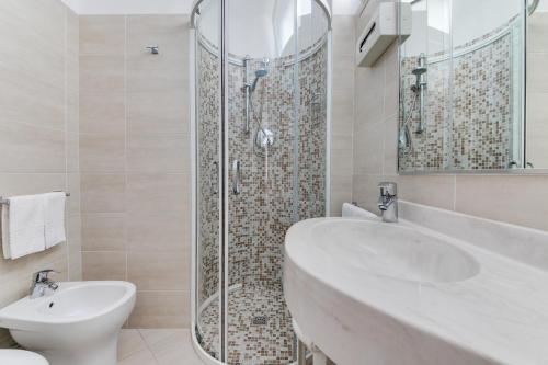 W łazience znajduje się umywalka, prysznic i toaleta. w obiekcie Hotel Cigno D'Oro w mieście Riccione