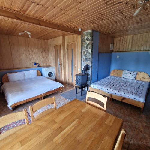 a room with two beds and a table and a stove at Griežto 5 in Zarasai
