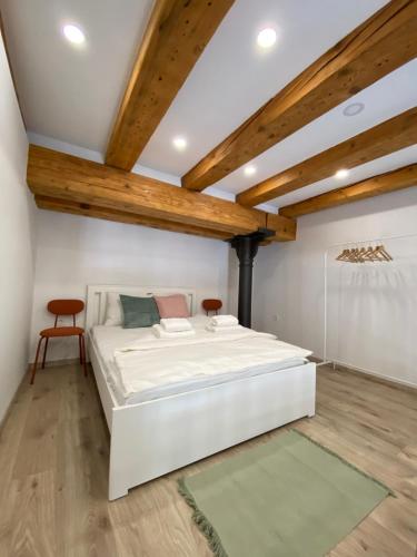 Una cama blanca en una habitación con techos de madera. en The Amazing Loft en Liubliana