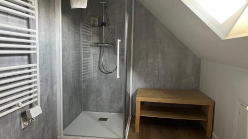 y baño con ducha y mesa de madera. en Le 24 Clemenceau, en Châtellerault