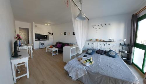 een slaapkamer met een groot bed en een woonkamer bij Estudios Center in Corralejo