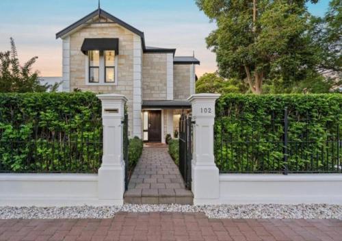 a house with a gate and a brick driveway at Executive living in City fringe location in Glenunga