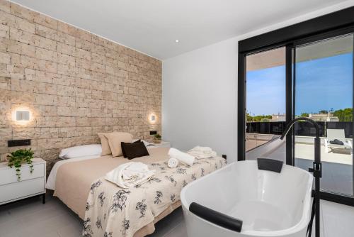 - une chambre avec 2 lits, une baignoire et un mur en briques dans l'établissement Villa Adela, à San Javier