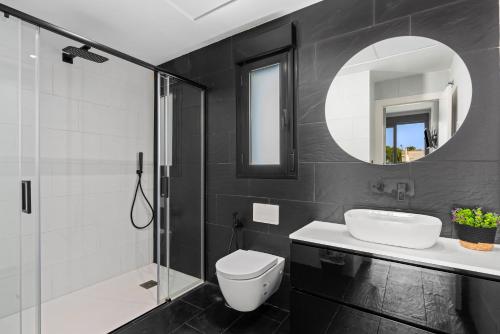 La salle de bains est pourvue de toilettes, d'un lavabo et d'un miroir. dans l'établissement Villa Adela, à San Javier