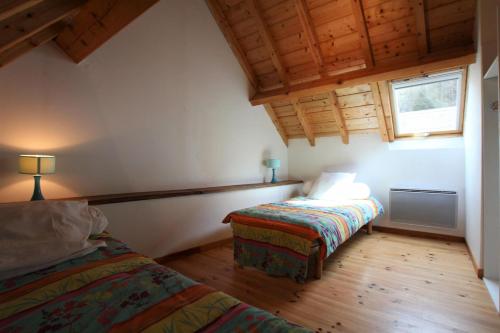 Accous的住宿－Petit aoulet，一间卧室设有两张床、一个窗户和木地板。