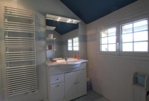 ein Bad mit einem Waschbecken und einem Fenster in der Unterkunft Petit aoulet in Accous