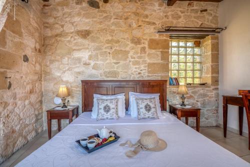 a bedroom with a bed with a tray of food on it at The Stonemade Houses in Falasarna