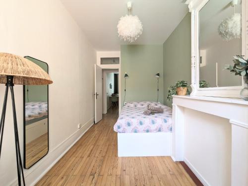 Schlafzimmer mit einem Bett und einem Spiegel in der Unterkunft Le DODO Part-Dieu in Lyon