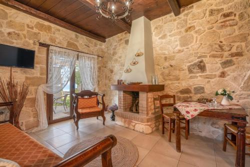 a living room with a stone wall and a fireplace at The Stonemade Houses in Falasarna