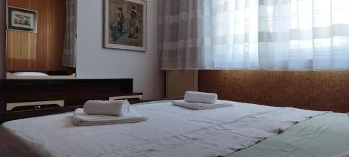 a bed with two towels on top of it at 7 Flower Street Apartment in Šempeter pri Gorici