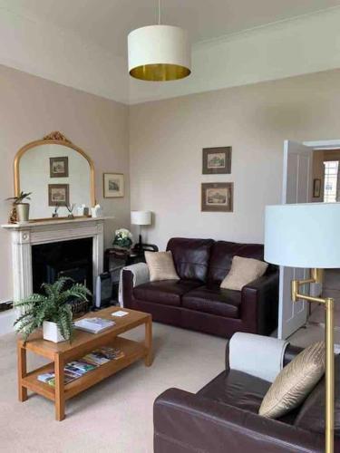 a living room with a couch and a table at Beautiful Regency Crescent Apartment in Idyllic Location in Bath