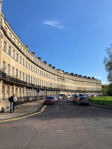 a large building with cars parked on the side of a street at Beautiful Regency Crescent Apartment in Idyllic Location in Bath