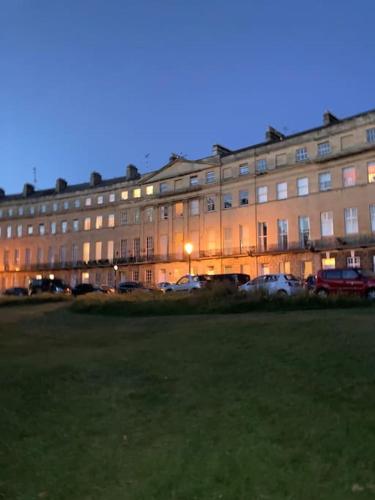 a large building with cars parked in front of it at Beautiful Regency Crescent Apartment in Idyllic Location in Bath