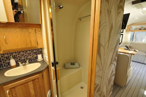 a small bathroom with a sink and a shower at Airstream Retro USA caravan in Earnewâld