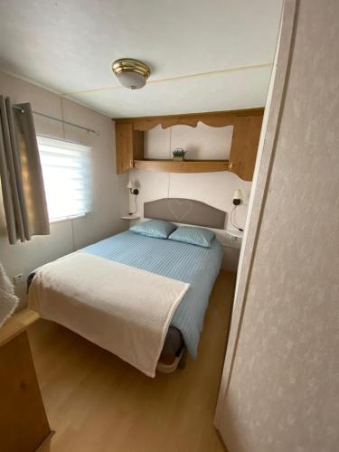 une petite chambre avec un lit et une fenêtre dans l'établissement Mobil Home à la Pointe de Pordic, à Pordic