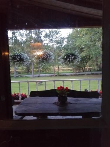 una mesa con un jarrón de flores encima de una ventana en Rava möis, en Rava