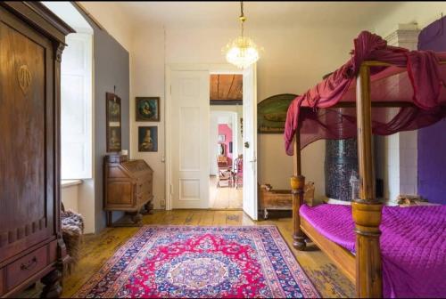 a bedroom with a canopy bed and a rug at Rava möis in Rava