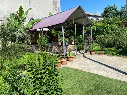 a garden with a pavilion with plants and flowers at Hotel Liza in Batumi