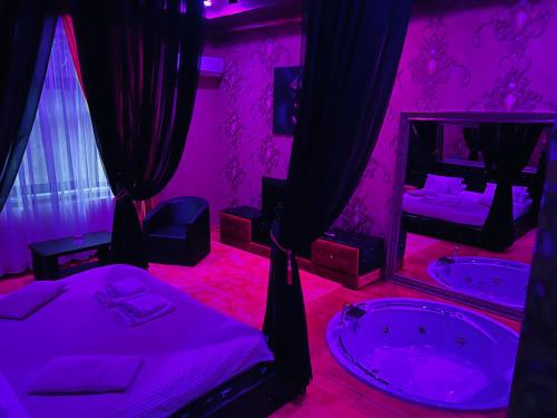 a bedroom with a tub and two beds and a mirror at Cetate Residence in Braşov