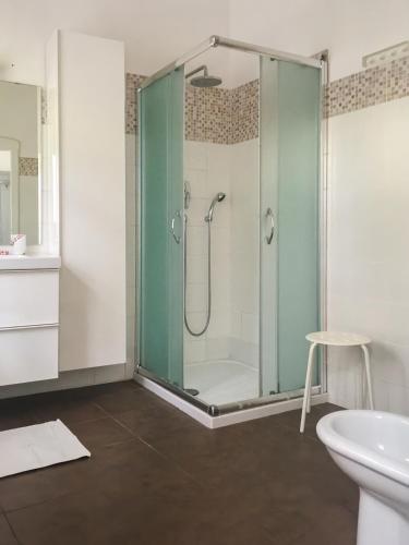 a bathroom with a glass shower with a sink at Villa Viola in Forlì