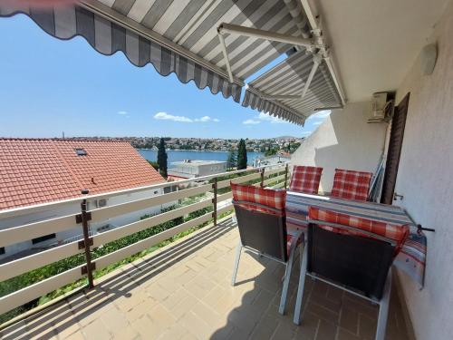 balcón con mesa, sillas y vistas al agua en Apartment Gordana, en Trogir