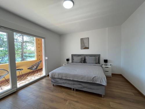 sypialnia z łóżkiem i balkonem w obiekcie Beach House Oliveglia (duplex house - 1st row to the sea) w mieście Šilo
