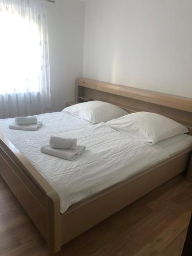 een bed met witte lakens en 2 handdoeken erop bij Ferienwohnung in Würm in Pforzheim