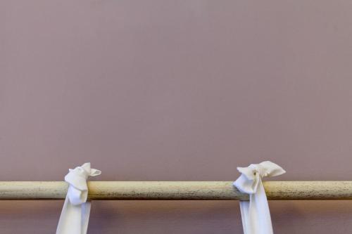 a wooden rail with two white bows on it at Hotel Ducale in Favaro Veneto
