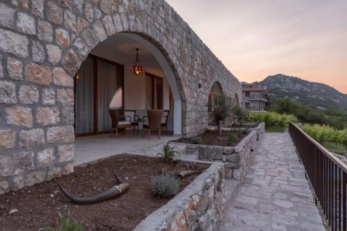 a stone house with a patio and a dining area at Apartments and Winery Djukovic in Virpazar