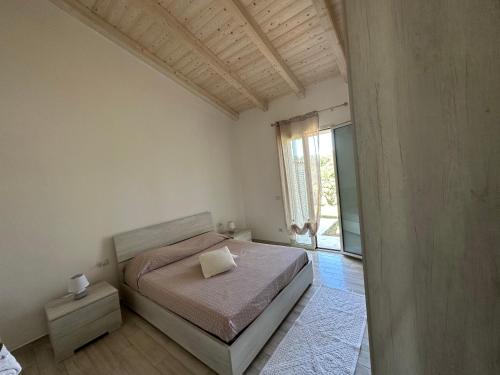 - une chambre avec un lit et une grande fenêtre dans l'établissement Appartamento i Pini, à Palau