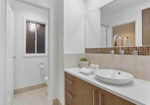 a white bathroom with a sink and a mirror at Executive living in City fringe location in Glenunga
