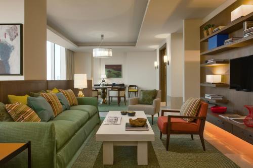 a living room with a green couch and a table at Assila, a Luxury Collection Hotel, Jeddah in Jeddah