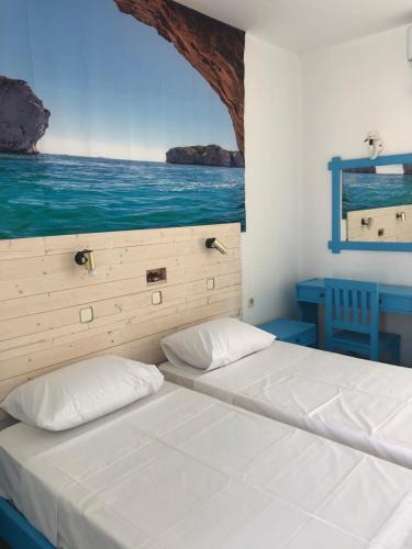 a bedroom with two beds and a view of the ocean at Antonis Hotel in Kefalos