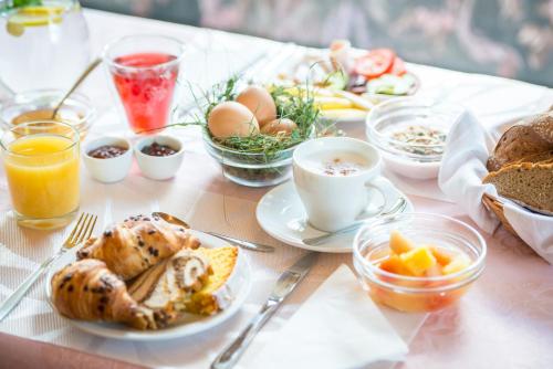 een tafel met borden met ontbijtproducten en -dranken bij Pension Tannenhof in San Giovanni in Val Aurina