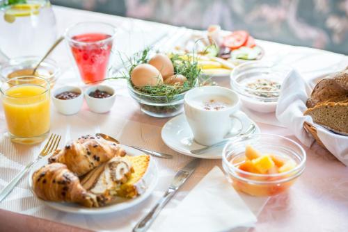 a table topped with plates of breakfast foods and drinks at Pension Tannenhof in San Giovanni in Val Aurina