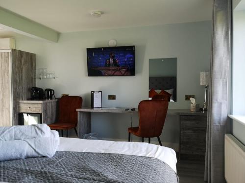 una camera con letto, tavolo e sedie di Tiernan's Luxury King Room Ensuite a Newtown-Dillon