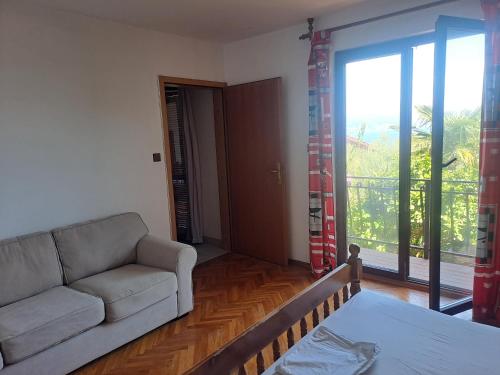 a living room with a couch and a large window at Apartment Camelia in Opatija