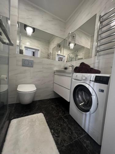 łazienka z pralką i toaletą w obiekcie Golden Era Apart w mieście Kryżanowka