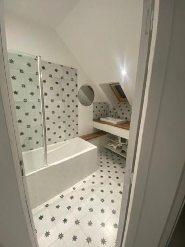 une salle de bain avec une baignoire et un miroir dans l'établissement Kermaria- Maison 10 pers - 4km Mer - Paimpol-Treguier, à Pleumeur-Gautier