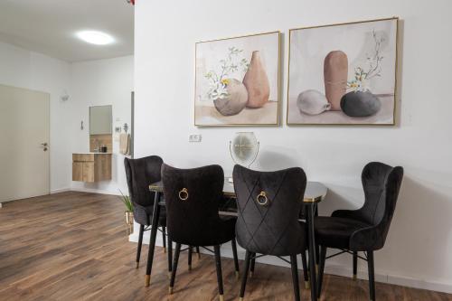 a dining room with a table and black chairs at צימר בכפר - סוויטות ובקתות קסומות עם בריכה מחוממת ונוף מהמם in Rama
