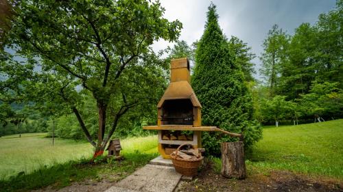 a bird house sitting in the grass next to a tree at Holiday House Sofia in Delnice