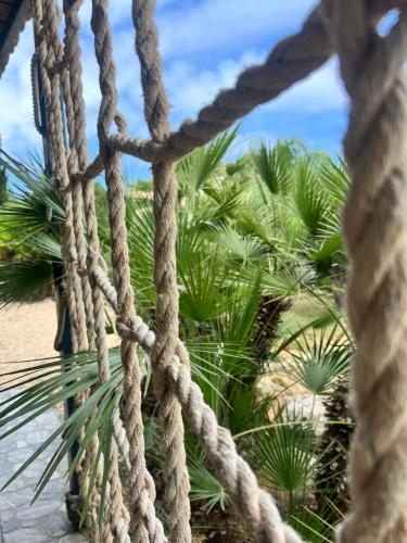 a rope bridge with palm trees in the background at Baglio Mazzara in Custonaci