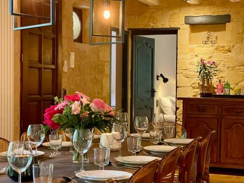 une table avec des verres et des fleurs au-dessus dans l'établissement Maison Saint-Blaise Rampieux, à Rampieux